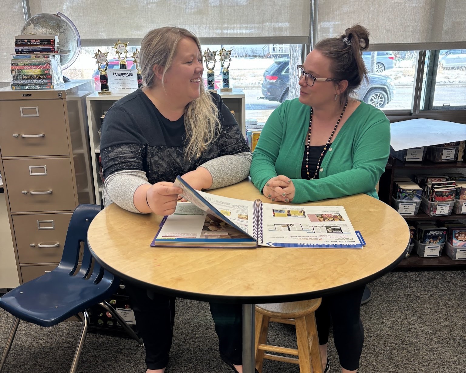 Teacher Candidate ashley summers and sara sholten at a table in their classroom