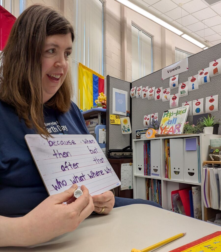 Teacher working with student through a small whiteboard